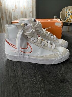Nike Women's White High-Top Sneakers with Orange Swoosh Accent